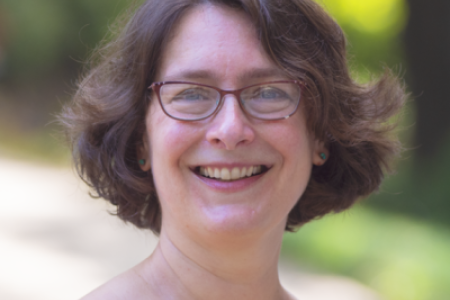 Photo of a woman's head against a blurred outdoor background